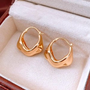 Macro detail of 18K gold plated earrings with irregular wrinkled texture in jewelry box