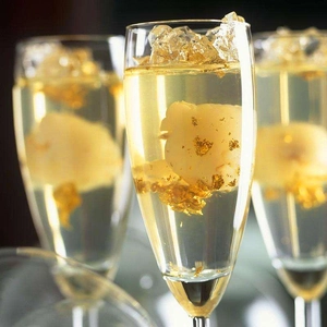 Macro shot of sparkling edible gold flakes floating in elegant champagne glasses