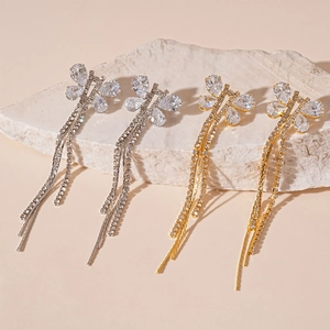 Elegant zircon butterfly tassel earrings in gold and silver finish on a stone display