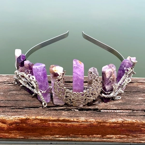 Detailed close-up of a silver moon and branch crown with raw purple crystals on wood