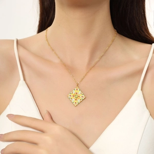 Detailed shot of a vintage gold geometric necklace with colorful enamel inlay on a model