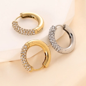 Macro detail of 14K gold and silver plated chunky C-shaped earrings with inlaid crystals