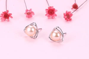 Detailed view of pink freshwater pearls on silver triangle studs with dried flowers