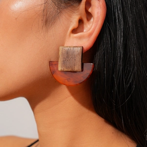 Nahaufnahme der quadratischen Holz- und Harzohrringe am Model für einen Retro-Mode-Look