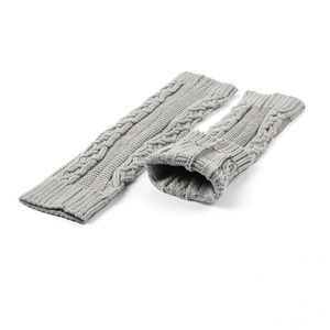 Close-up of grey cable-knit leg warmers with thick texture on white background