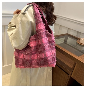 Pink checkered plaid tote bag with fringe details styled on model with a beige coat