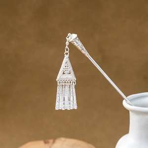 Detail of silver vintage hairpin with hollow triangle pendant and elegant tassels