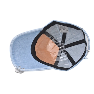 Washed light blue denim baseball hat featuring silver metal rings on the brim