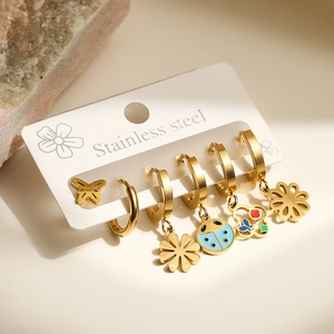 Detailed macro view of stainless steel earring set with colorful butterfly and floral charms