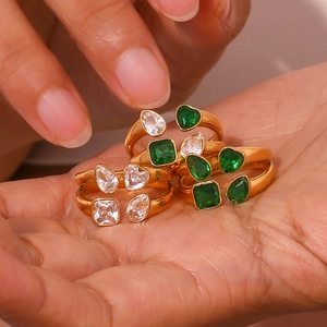 Macro detail of six gold open rings with heart and pear-shaped zircon stones in palm