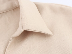 Detailed close-up of V-neck stitching and lace texture on a beige casual blouse