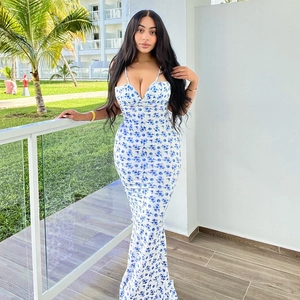 Detail of white summer maxi dress with blue floral print and slim spaghetti straps