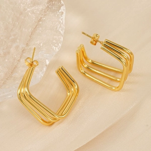 Detail of 18K gold plated three-layer geometric square earrings on silk fabric