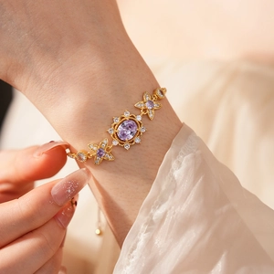 Close-up of a vintage gold bracelet featuring purple oval stones and zircon flowers