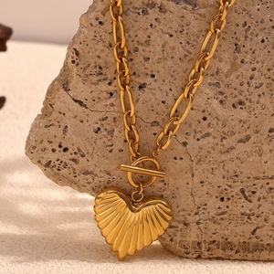 Macro shot of 18K gold plated heart pendant with textured finish and OT toggle clasp