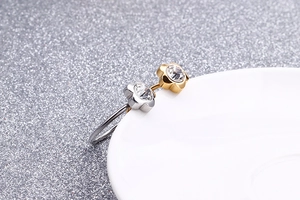 Macro detail of a flower-shaped zircon titanium steel ring with gold and silver bicolor finish
