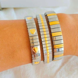 Detail of three stretchable stainless steel bracelets with heart and geometric patterns