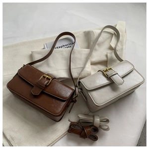 Detail view of vintage oil wax leather crossbody bags in brown and beige colors