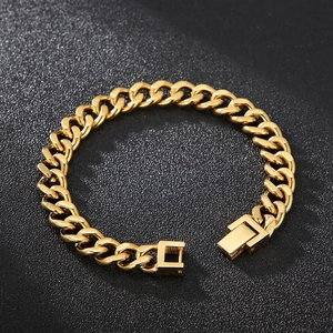 Gros plan d'un bracelet gourmette doré avec fermoir carré sur fond sombre texturé