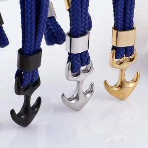 Close-up of anchor clasps in black, silver, and gold on braided multilayer bracelets