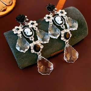 Detail of vintage flower portrait earrings with crystal studs and black rose charms