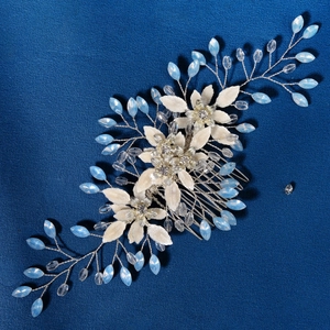 Pettine sposa con fiori di stoffa bianchi e perle di cristallo blu su sfondo scuro