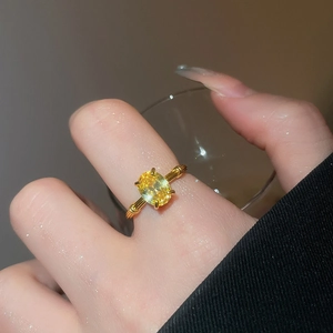 Detail of three-layer golden ring featuring a yellow oval zircon and bamboo texture