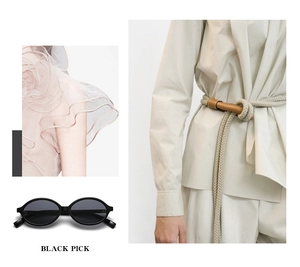Detail of vintage oval black sunglasses paired with stylish rope belt and beige apparel