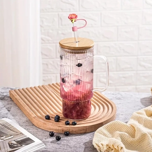 Pink peach blossom silicone straw cover cap on a glass tumbler with wooden lid