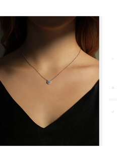 Primo piano della collana con ciondolo in moissanite su modella con luce laterale drammatica