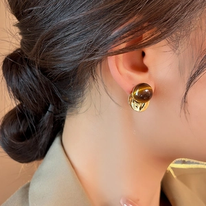 French vintage tiger eye stone geometric round stud earrings on a model in beige suit