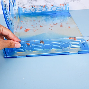 Detail view of blue translucent resin organizer tray featuring embedded gold leaf flakes