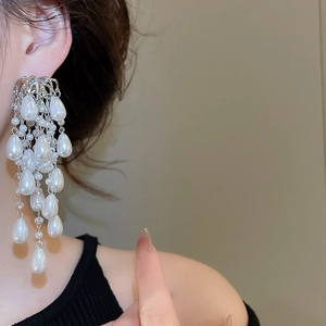 Detail of silver drop tassel pearl earrings showing multi-layered fringe design