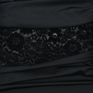 Close-up of black one-shoulder dress showing smooth fabric and floral lace patchwork detail