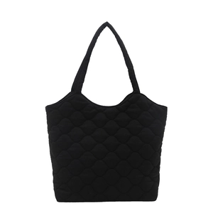 Minimalist black quilted tote bag with diamond lattice pattern for women on white background