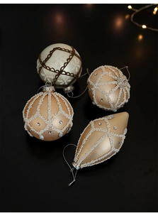 Detail of luxury white Christmas ornaments with pearls and embroidery on black background
