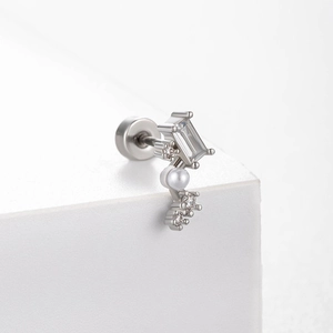 Boucle d'oreille en acier titane lune étoile avec zircon et perle sur socle blanc