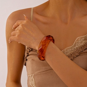 Macro shot of amber resin geometric cuff bracelet with irregular marbled pattern