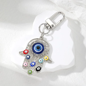 Vintage Hamsa Hand keychain with colorful evil eye charms and rhinestones on stone surface