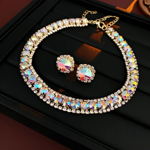 Detail view of double-layer gold necklace and stud earrings with rainbow crystals