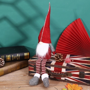 Gnomo di Natale a strisce rosse e bianche seduto su una valigia vintage Union Jack