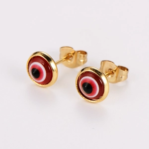 Macro detail of gold stainless steel stud earrings with red and black evil eye pattern