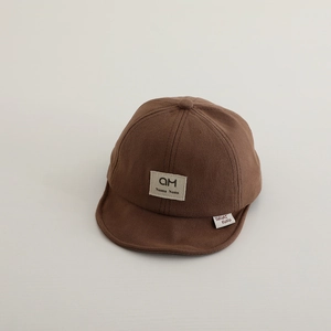 Close-up of soft-brim dark brown baby baseball cap showing detailed cotton fabric and logo