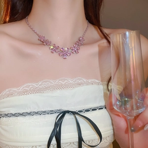 Detail of pink zircon flower necklace worn by a model in a luxury evening setting