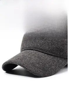Detail of dark grey winter baseball cap showing thick wool fabric and black metal logo