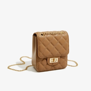 Detail of a brown quilted crossbody bag featuring a golden chain strap and twist-lock