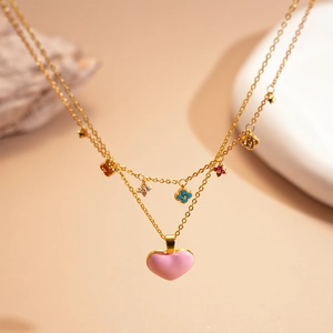 Double-layered gold necklace with colorful clover motifs and a pink heart pendant