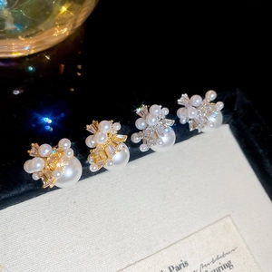 Macro detail of firework pearl earrings with cubic zirconia in gold and silver finish