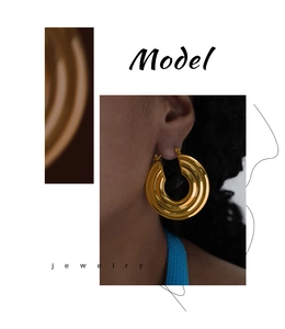 Detail of gold triple-layered textured hoop earrings made of elegant titanium steel