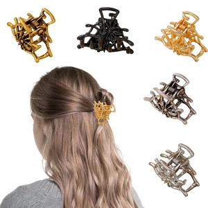 Détail de pinces à cheveux araignée en métal de diverses couleurs portées par un modèle